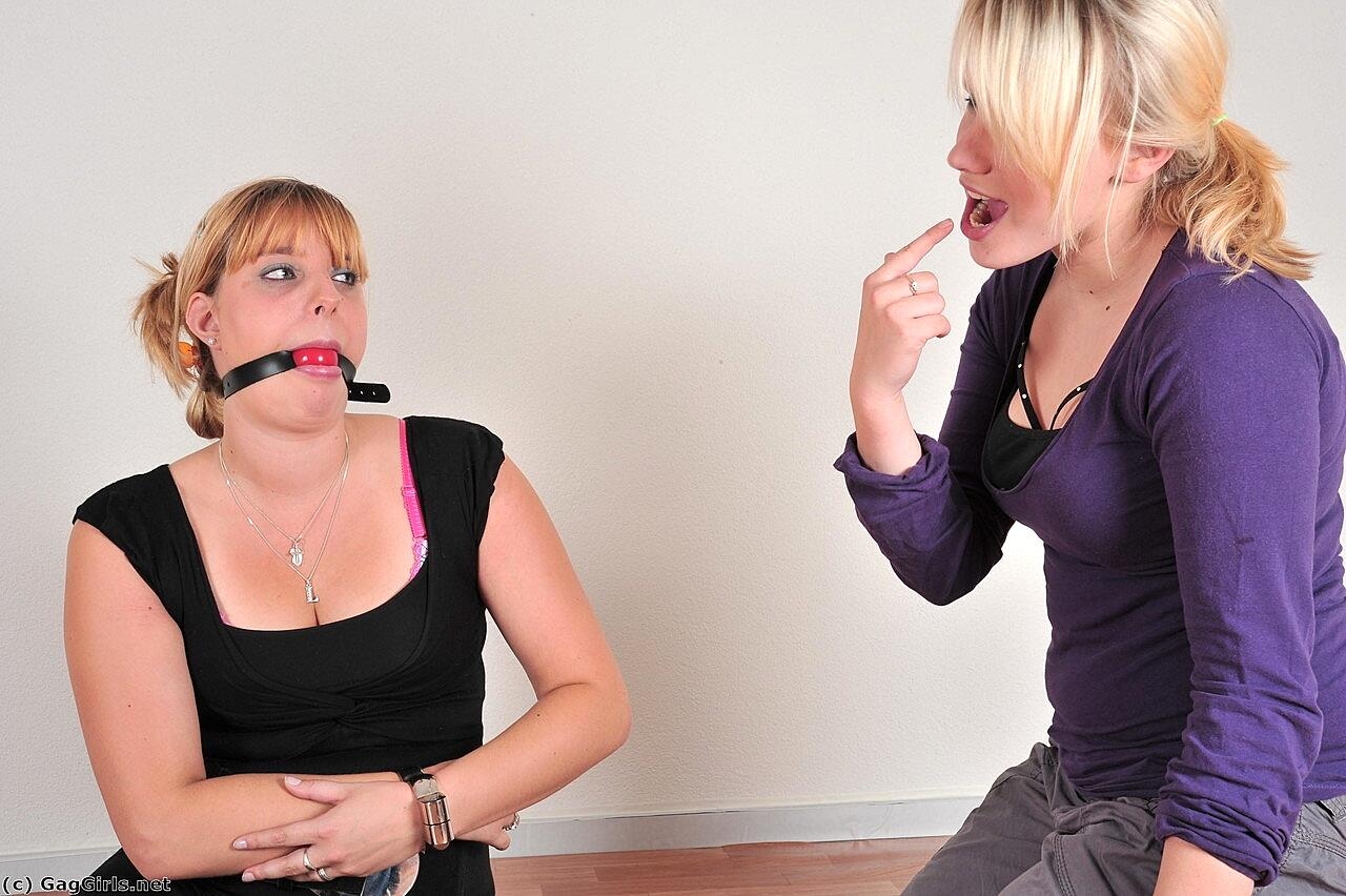 Fully clothed lesbians Mau and Lau outfit each other with ball gags